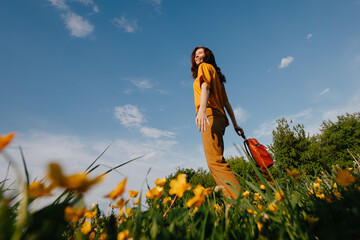 A young slender woman stands against a blue sky in a yellow field, bottom view. Freedom from allergies.