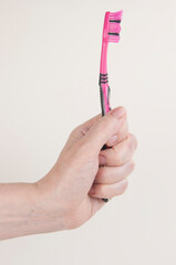 Woman hand holding a toothbrush on a white background