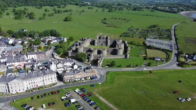 Sunny touristic Beaumaris castle town aerial slow descending view ancient Anglesey fortress landmark