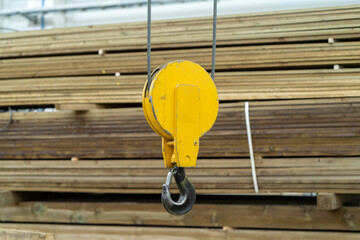 Overhead beam crane hook in factory warehouse, close up.