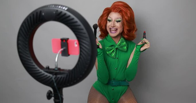Drag queen influencer doing social media live teaching makeup to her followers - Technology and lgbt concept