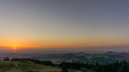 Fototapeta na wymiar Sunset from Wasserkuppe, the highest point in Roehn Mountains under a clear sky, Germany