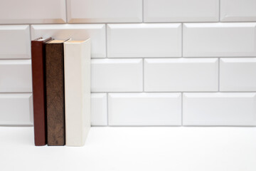 Blank books on white brick wall. Copy space free for text.