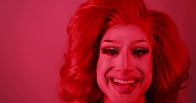 Drag queen smiling on camera with red light inside studio - Lgbtq concept 