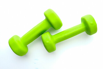 Green dumbbells on a white background. Sports and fitness.