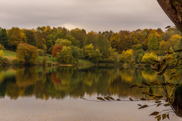 caldera lake of Ulmen with view at colorful forest in autumn, Germany