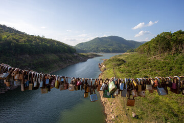 big river mountain landscape forest sky many padlocks are hanging in the foreground. The concept of...