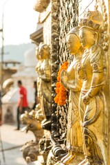 Fototapeta premium Closeup of religious statues glittering gold at sunset.