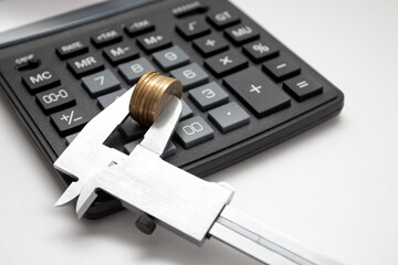Calculator and Coin in Caliper. Business and financial