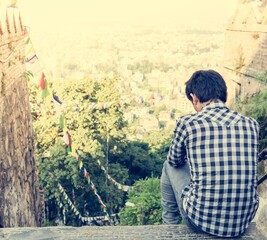 Young man sitting on top of ancient staircase.