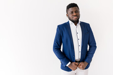 Head shot of serious african american young man wearing white shirt and suit looking at camera standing on white blank background, copy space studio shot. Focused concentrated young businessman