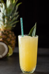 Cocktail with pineapple, coconut and lemon on stone background