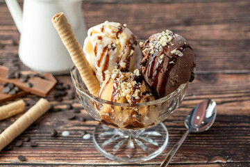 Chocolate, cream and caramel Roma ice cream in a glass bowl with hazelnut and chocolate sauce poured over it.
