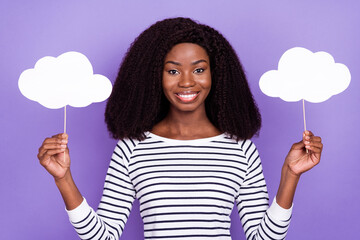 Portrait of attractive cheerful girl holding in hands clouds on sticks copy space isolated over violet purple color background