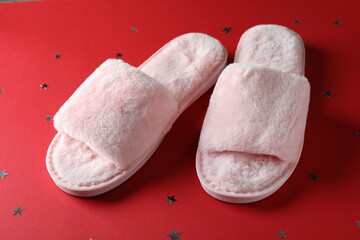 Pair of house slippers on red background