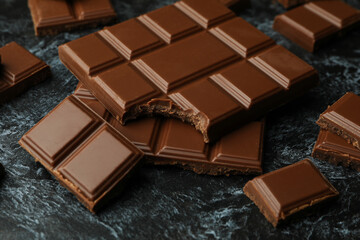 Tasty chocolate bars on black smokey background