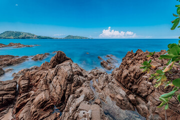 Beautiful rocky sea in the summer of Patong Beach, Phuket, Thailand, on a sunny day overlooking the horizon and blue sky. with the turquoise sea Taken with the long shutter technique.