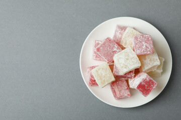 Plate with delicious turkish delight on gray background