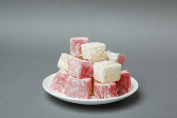 Plate with delicious turkish delight on gray background