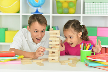 Portrait of brother and sister playing with wooden blocks at playroom