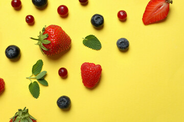Fototapeta na wymiar Delicious fresh berry mix on yellow background