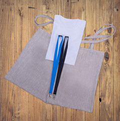 
Composition from Blank promo products-grey tote bag canvas, Blue and black Lanyards Neck Strap with Metal Lobster Clip. white t-shirt. Over view on wooden desk.