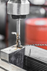 A tap on a machine for tapping a hole in a part.