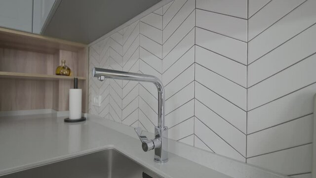 Closeup of tap and sink at luxury moden classic gray kitchen