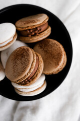 Macaroons on light bright background, colorful french cookies macaroons. Macaroons. Vanilla and chocolate dessert. Healthy no sugar vegetarian. Gift for 8 March - International Women's Day