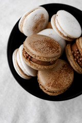 Macaroons on light bright background, colorful french cookies macaroons. Macaroons. Vanilla and chocolate dessert. Healthy no sugar vegetarian. Gift for 8 March - International Women's Day