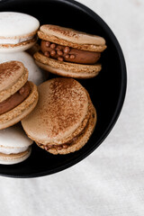 Macaroons on light bright background, colorful french cookies macaroons. Macaroons. Vanilla and chocolate dessert. Healthy no sugar vegetarian. Gift for 8 March - International Women's Day