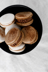 Macaroons on light bright background, colorful french cookies macaroons. Macaroons. Vanilla and chocolate dessert. Healthy no sugar vegetarian. Gift for 8 March - International Women's Day