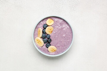 Obraz na płótnie Canvas Smoothie bowl with banana, blueberries, oatmeal and chia seeds. Diet food. Top view.