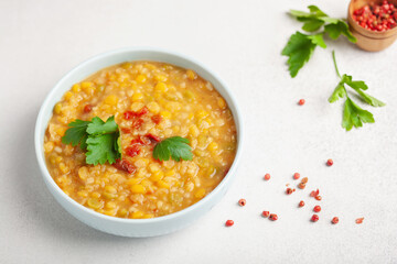 Homemade peas lentil soup with pepper and parsley  in  bowl on a table. Indian Dahl