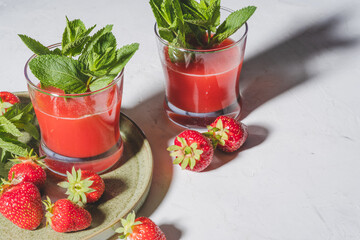 Fresh strawberry juice, cold summer juicy fruits cocktail with mint, hard light