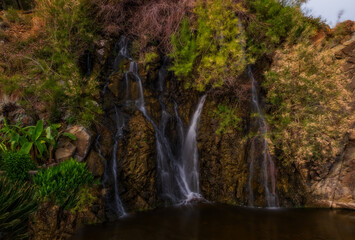 Fototapeta na wymiar Artificial waterfall in Tekirova, Turkey in a beautiful day in May 2021. Picture taken near rixos hotel tekirova. Long exposure shot.