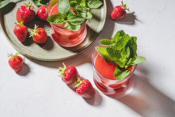 Fresh strawberry juice, cold summer juicy fruits cocktail with mint, hard light