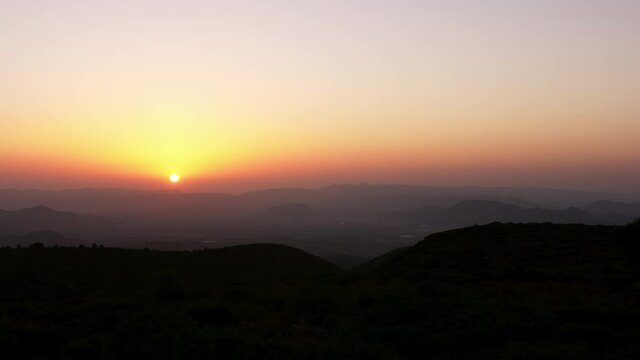 Timelapse sunrise at the mountains of Enguera, south of spain. The sun rises and conforms a solar disc. No clouds.