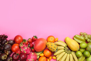 Many different delicious exotic fruits on pink background, flat lay. Space for text