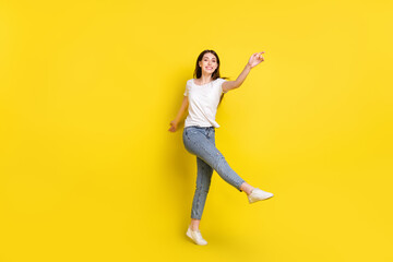 Fototapeta na wymiar Full length body size photo pretty girl smiling dancing cheerful at party isolated vibrant yellow color background