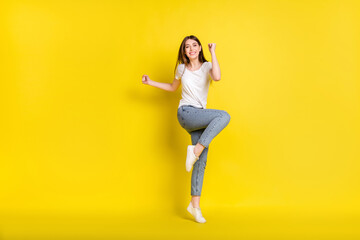 Full size photo of young girl happy positive smile rejoice win winner victory success fists hands isolated over yellow color background