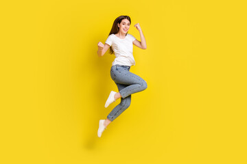 Fototapeta na wymiar Full length body size view of attractive cheerful girl jumping rejoicing isolated over bright yellow color background
