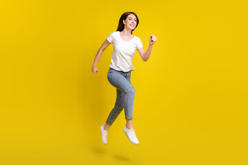Full length profile side photo of young girl happy positive smile go walk run hurry sale jump isolated over yellow color background