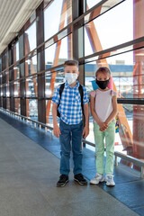 Fototapeta premium First time at airport. Two little kids going on vacations trip with backpacks at international airport, indoors. Children waiting boarding in terminal