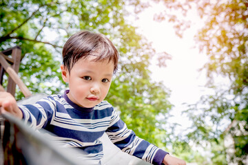Little asian boy playing wooden slider and happy fun or cheerful enjoy on holiday. kid at the...
