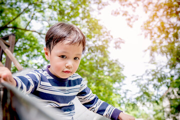 Little asian boy playing wooden slider and happy fun or cheerful enjoy on holiday. kid at the playground. Background. Copy space. Learning Concept.