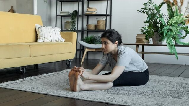 Young fit woman warm up stratching on the floor, workout for healthy lifestyle at home. Sport and fitness. Training and wellness concept.