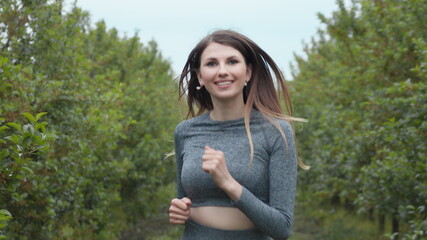 Obraz premium Front Follow up Shot of Girl Athlete Running Alone Down, Getting Ready for a Race Competition or Marathon. Test of Human Endurance. Young Fit Woman in Sportswear Jogging Alone. Slow Motion