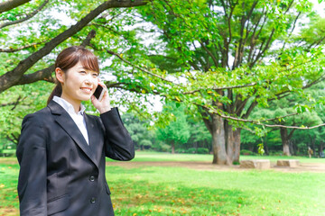 Fototapeta premium 電話をするスーツ姿の若い女性
