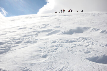 Group of mountaineers walking trough the mountains covered with snow...